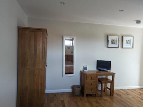 a room with a desk and a mirror and a door at The Willoughby in Little Bytham