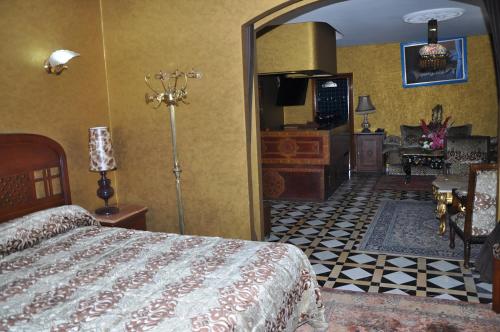 a bedroom with a bed and a living room at Hôtel Transatlantique in Casablanca