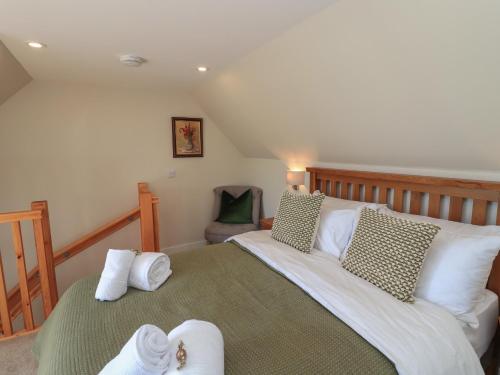 a bedroom with a large bed with towels on it at Wee Smithy in Munlochy