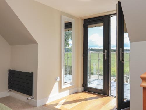 a room with doors that lead to a balcony at Wee Smithy in Munlochy