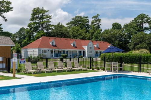 a house with a pool in front of a fence at Hotel Manteo in Manteo