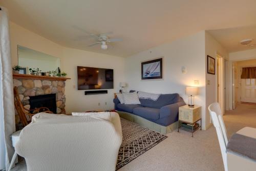 a living room with a blue couch and a fireplace at Beachfront Onekama Vacation Rental with Balcony! in Onekama