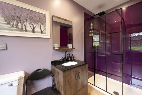 uma casa de banho roxa com um lavatório e um chuveiro em Glen View em Inverness