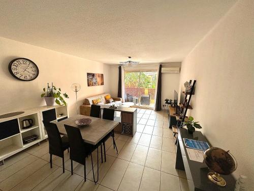 a living room with a dining table and a kitchen at Malibu Village T2 in Canet-en-Roussillon