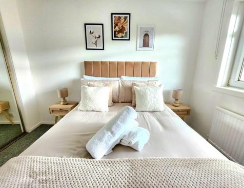 a bedroom with a large bed with two pillows on it at Quirky Home, Quiet Neighbourhood in Newton Mearns