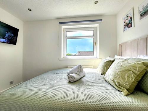 a bed with a towel on it in a bedroom at Quirky Home, Quiet Neighbourhood in Newton Mearns