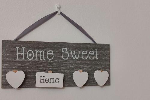 a sign that says home sweet home with hearts at Panos & Maria studio! in Kalamata