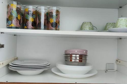 a white shelf with plates and bowls on it at Panos & Maria studio! in Kalamata