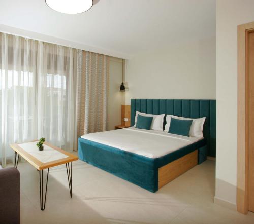 a bedroom with a large bed and a table at Oliva Suites in Keramoti
