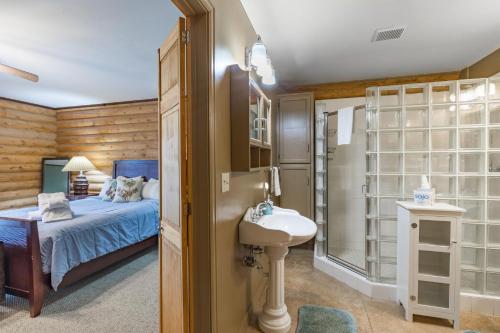 ein Schlafzimmer mit einem Bett, einem Waschbecken und einer Dusche in der Unterkunft 13655 County Road 1 in Ridgway