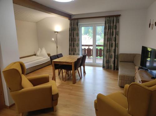ein Wohnzimmer mit einem Tisch, Stühlen und einem Sofa in der Unterkunft Amadee Appartements in Bad Kleinkirchheim