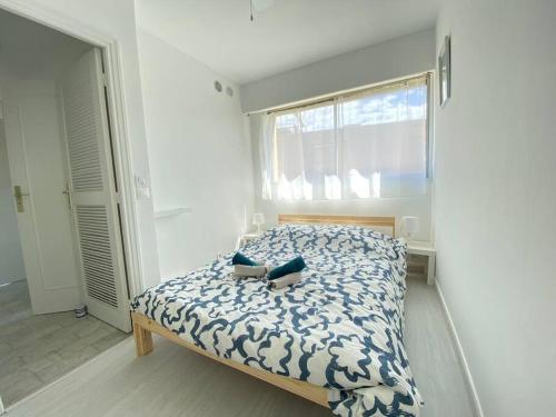 um quarto com uma cama com um edredom azul e branco em 06AT2 - Cosy seaside T2 ideally located em Antibes