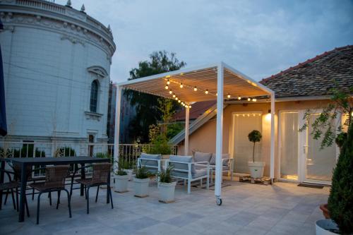 a pergola with a table and chairs on a patio at Apartman Centar in Sremski Karlovci