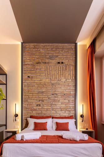 a bedroom with a brick wall and a large bed at Trastevere 143 in Rome