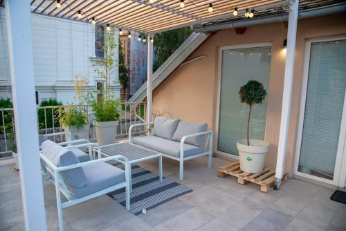 a patio with chairs and a couch on a porch at Apartman Centar in Sremski Karlovci