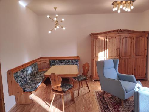 ein Esszimmer mit einem Tisch und einem blauen Stuhl in der Unterkunft Amadee Appartements in Bad Kleinkirchheim