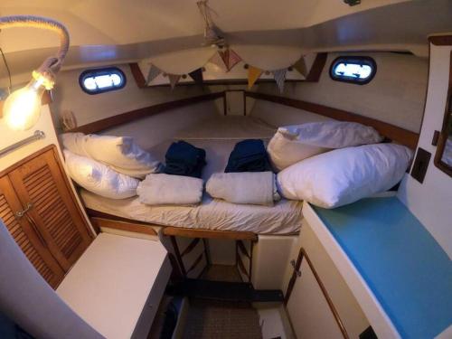 Cette petite chambre comprend des oreillers sur un bateau. dans l'établissement Voilier traditionnel, tout confort et au calme, à Gruissan