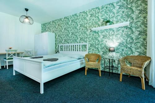 クラーシュテレツ・ナト・オフジーにあるPension u Jezuのベッドルーム1室(白いベッド1台、椅子2脚付)
