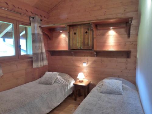 deux lits jumeaux dans une chambre aux murs en bois dans l'établissement Appartement 3 pièces à Méribel avec piscine couverte et WiFi - FR-1-411-406, à Les Allues
