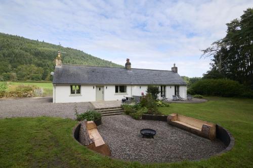 a small white house with a garden in front of it at Upper Dunain in Inverness