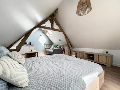 ein Schlafzimmer mit einem großen Bett im Dachgeschoss in der Unterkunft Le paradis Bucheois in Buchy