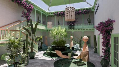 a lobby with plants and chairs and a staircase at César Lanzarote Luxury Boutique Hotel - Adults Only in La Asomada