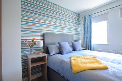 a bedroom with a bed with a yellow blanket on it at Portmore Holiday Home in Portrush