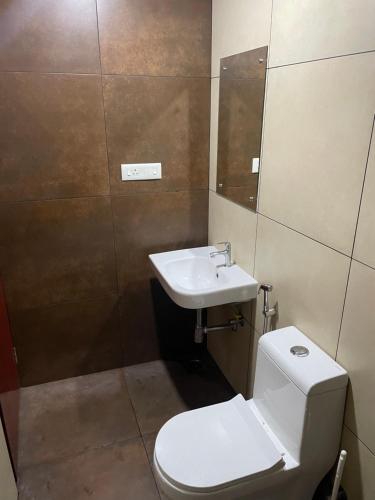 a bathroom with a toilet and a sink at Uniro Rooms & Packages in Cochin