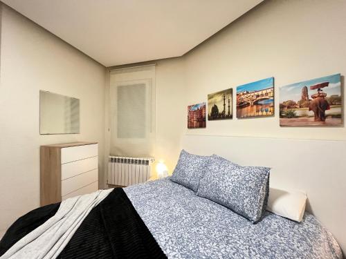 1 dormitorio con 1 cama y algunas fotos en la pared en Acogedor Atocha Ile Sebastian, en Madrid