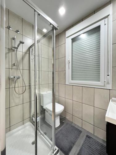 baño con ducha y aseo y ventana en Acogedor Atocha Ile Sebastian en Madrid