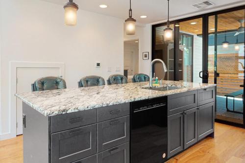 a kitchen with a sink and a counter with chairs at Cozy Austin Hideaway in Austin
