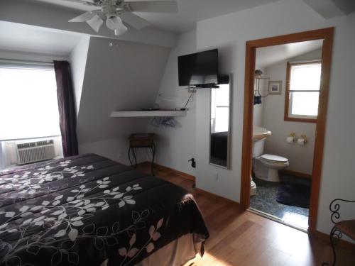 a bedroom with a bed and a bathroom with a toilet at Sunset Inn in South Haven