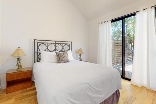 a bedroom with a white bed and a large window at Cozy Austin Hideaway in Austin