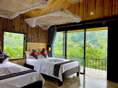 sypialnia z 2 łóżkami i balkonem z oknami w obiekcie Hmong house Sapa w mieście Sa Pa