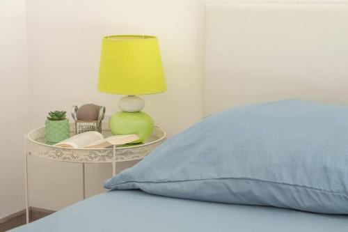 a bed with a blue pillow and a lamp on a table at Nouveau - Le Privacy - Europa Park in Sand