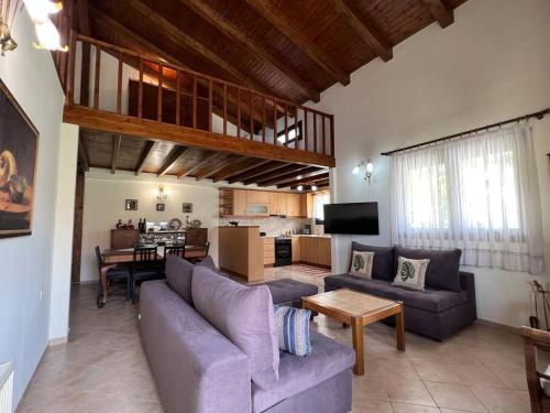 sala de estar con 2 sofás y comedor en Zaros Cottage, en Zarós