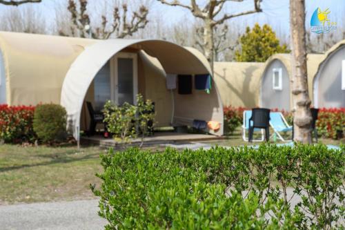 a house with a tent in a yard at Camping Rose in Dormelletto