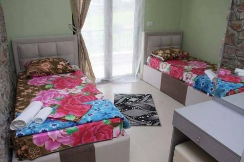 a room with two beds and a desk at Hotel Villa Stone Dream Bar Restaurant in Pogradec