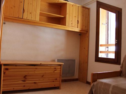 une chambre avec un lit et une commode en bois dans l'établissement Duplex 3* au centre de Valloire, proche télécabine, 6 pers, balcon - FR-1-263-423, à Valloire