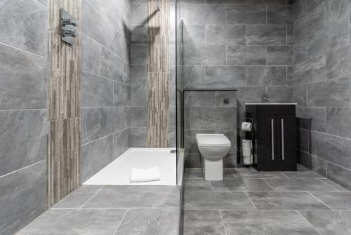 a bathroom with a toilet and a walk in shower at Temple Court by UStay Aparthotels in Liverpool