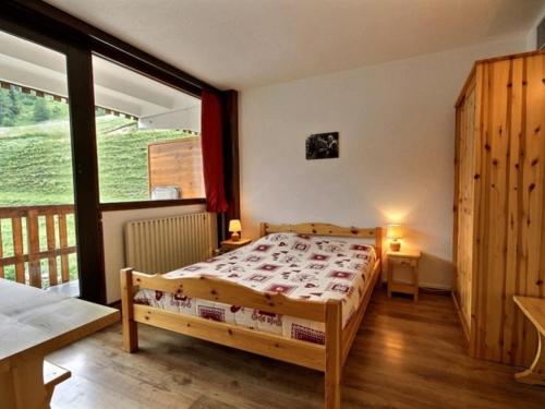 une chambre avec un lit et une grande fenêtre dans l'établissement Bel appartement rénové, 3 chambres, proche pistes, parking, animaux acceptés - FR-1-455-25, à La Plagne