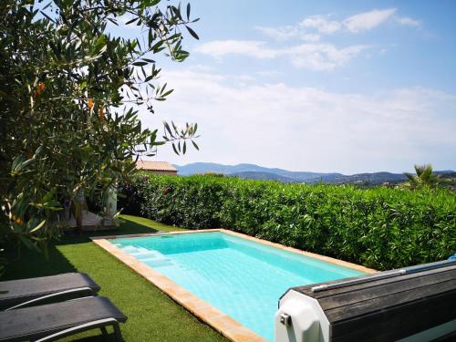 - une piscine dans l'herbe à côté d'un banc dans l'établissement VILLA AVEC APERCU MER ET PISCINE PRIVEE, à Sainte-Maxime