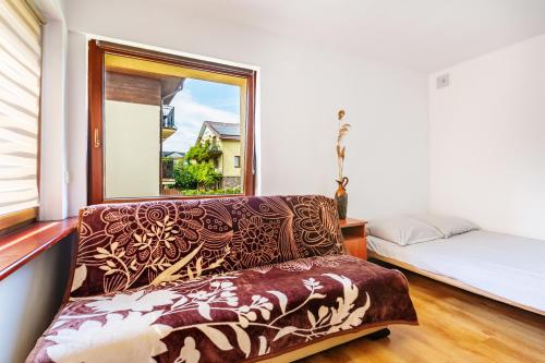 a couch in a room with a window and a bed at Apartamenty Maciejka in Władysławowo