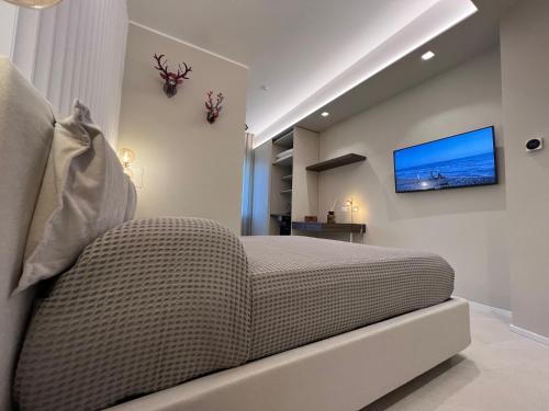 a bedroom with a bed and a tv on the wall at EMPATIA PESCARA CENTRO in Pescara