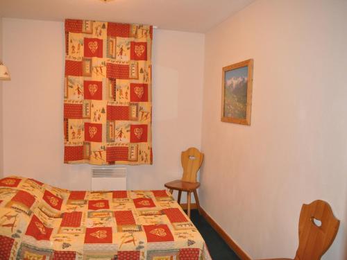 - une chambre avec un lit recouvert d'une couette dans l'établissement Appartement 3 pièces 6 pers avec balcon, accès piscine, à 700m du centre de Valloire. - FR-1-263-437, à Valloire