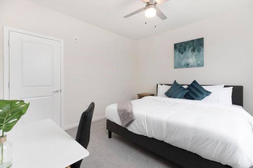 a white bedroom with a bed and a ceiling fan at Modern Stylish Concord Condo in Concord