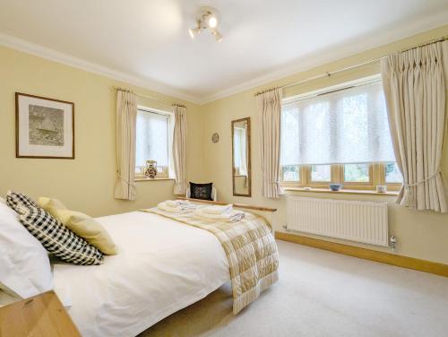 a bedroom with a large white bed and windows at Wisteria Way, Tangmere in Tangmere