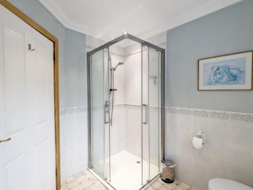 a shower with a glass door in a bathroom at Wisteria Way, Tangmere in Tangmere