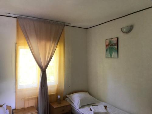 - une chambre avec un lit et une fenêtre avec un rideau dans l'établissement Casa postolache, à Soveja