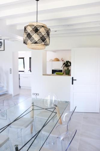 a dining room with a glass table and chairs at L'hermine de Sologne in Courmemin